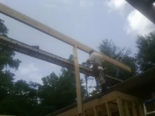Carpenter setting a ridge beam over a new addition frame — Ice Dam Removal by Roofing Brothers in Verbank