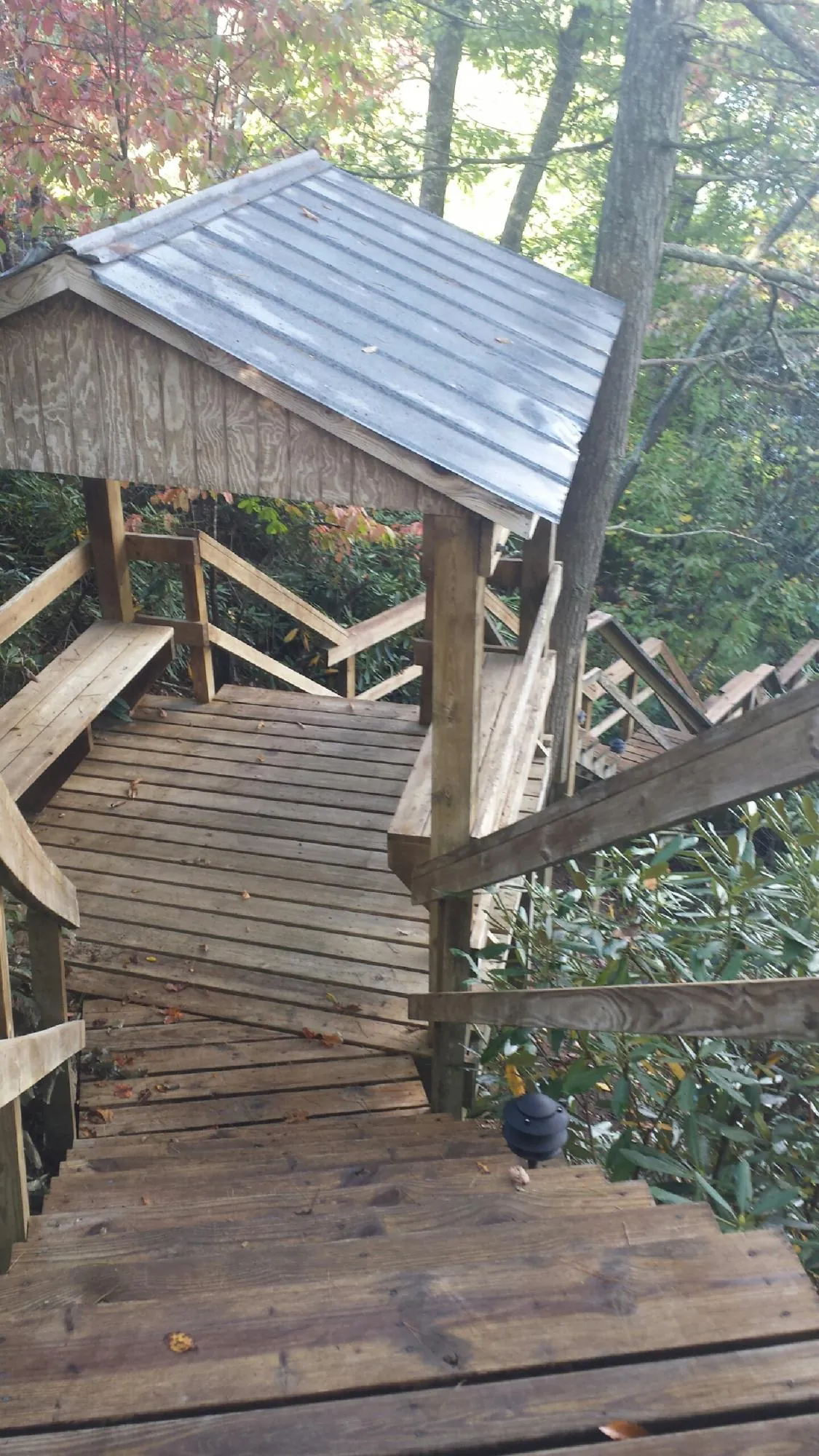 Metal roofed shelter over wooden steps on a wooded walkway — Skylight Repair & Installation work by our crew in Verbank
